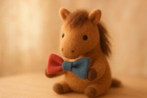 羊毛フェルトのお馬さんが、ラッキーカラーの赤と青のリボンをもっている
